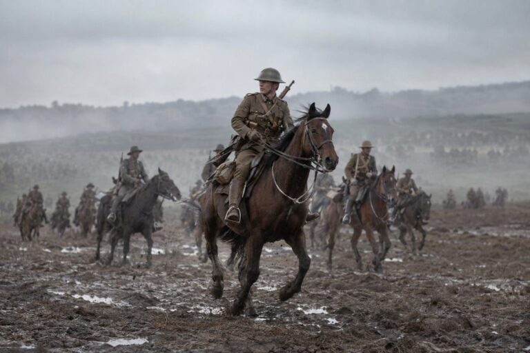 Cavaliers à cheval en uniforme militaire durant la Première Guerre mondiale avec soldats et chevaux en arrière-plan